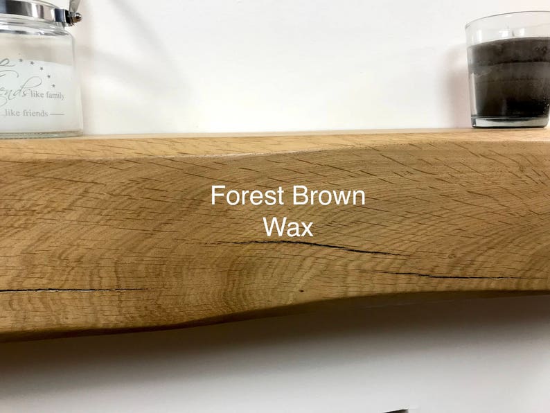 May include: A rustic, wooden shelf with a natural, light brown finish. The text "Forest Brown Wax" is printed on the shelf. A glass jar and a candle are on the shelf.