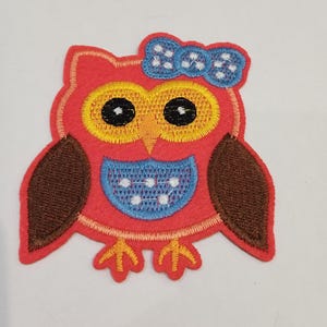 Peut inclure: Écusson brodé en forme de hibou, rouge, marron, jaune, bleu et blanc. Le hibou a de grands yeux jaunes avec des pupilles noires, un nœud bleu et une poitrine bleue avec des points blancs. Conçu pour être cousu ou repassé sur du tissu.