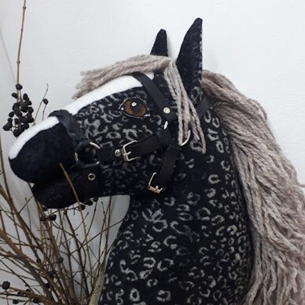 Black hobby horse with a white spot with brown eyes and made of thick velor with a rare pattern imitating the skin of a horse in apples