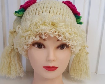 Parrucca-cappello lavorata a maglia per bambini per un servizio fotografico, bianca, con rose lavorate a maglia.