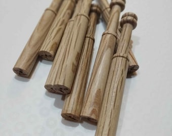 May include: A group of wooden bobbins with a striped pattern. The bobbins are stacked on top of each other and are all the same size.