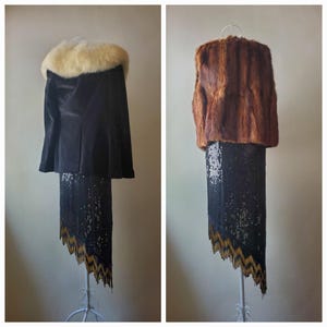 Può includere: Due outfit vintage esposti su manichini. Uno presenta un mantello nero con collo in pelliccia color crema sopra una gonna di paillettes nera con orlo a zig-zag oro e nero. L'altro outfit è una giacca di pelliccia marrone sopra la stessa gonna.