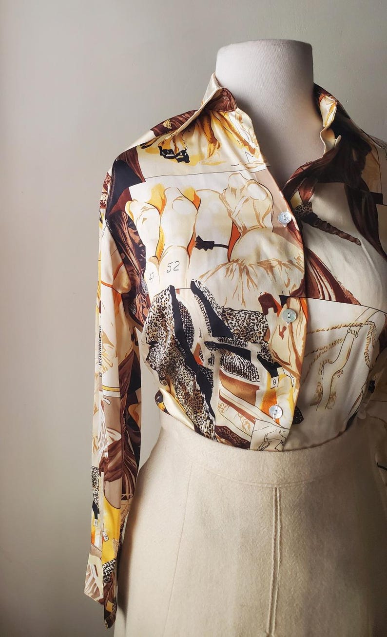 Puede incluir: Una camisa vintage estampada con fondo crema. La camisa presenta un estampado de figuras, estampado de leopardo y dise&ntilde;os abstractos en marr&oacute;n, negro y naranja. Se combina con una falda color crema, creando una est&eacute;tica retro.