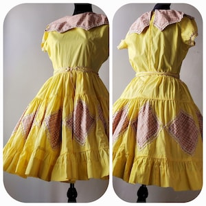 May include: A yellow vintage dress with a pink and white gingham collar and trim. The skirt has a layered design with pink and white gingham panels.