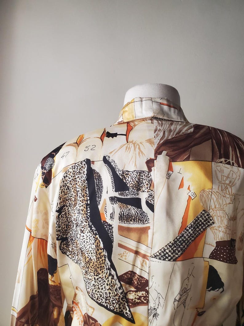 Puede incluir: Una camisa con cuello con un dise&ntilde;o de patchwork &uacute;nico. La camisa presenta una mezcla de estampados, incluyendo estampado de leopardo, formas geom&eacute;tricas y figuras abstractas en tonos crema, marr&oacute;n, negro y naranja. El n&uacute;mero "52" es visible.