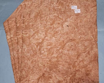 May include: Five sheets of wood veneer with a brown and orange burl pattern. The sheets are stacked on top of each other. A label on the top sheet reads "292 20x31 1/4".