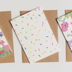 May include: Three birthday invitations with dinosaur graphics and the text "Stomp Chomp & Roar, let's party like a Dinosaur". The invitations are on brown envelopes, with a white background. The invitations have a pink, purple, and blue color scheme.