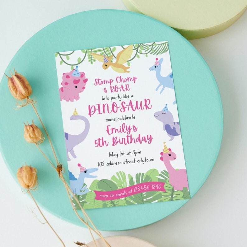 May include: A colorful dinosaur-themed birthday invitation. The invitation features cartoon dinosaurs, the text "Stomp Chomp & ROAR," and details for Emily's 5th birthday. The invitation is on a light blue circular surface.