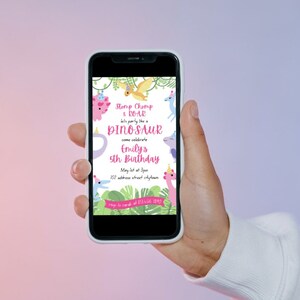 May include: A smartphone displays a colorful dinosaur-themed birthday invitation. The invitation features the text "Stomp Chomp & ROAR" and "DINOSAUR" in a playful font, along with details for Emily's 5th birthday. The design includes cartoon dinosaurs and tropical foliage.