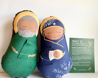 May include: A set of three handmade felt Christmas ornaments depicting the Nativity scene. The ornaments are green, blue, and white with embroidered details. The text on the card reads "Nativity Set: The Theotokos, Righteous Joseph and the Infant Jesus".
