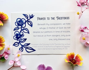 May include: A rectangular white card featuring the text Prayer to the Theotokos, followed by a prayer and historical note. A blue ink illustration of a floral vine runs along the left side. The card is surrounded by various colorful flowers.