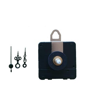 Pode incluir: Um movimento de relógio preto com uma porca dourada e um gancho de metal. Três ponteiros de relógio pretos estão à esquerda. O movimento do relógio é quadrado e tem um mostrador circular. Os ponteiros têm desenhos decorativos.