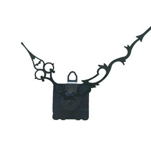 Può includere: Un movimento dell'orologio nero con lancette decorative. Il meccanismo dell'orologio è quadrato con un ingranaggio circolare e un anello per appendere. Le lancette hanno disegni curvi e ornati, adatti a un orologio vintage.
