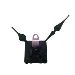 Può includere: Movimento dell'orologio nero con tre lancette nere. Il meccanismo dell'orologio ha un corpo nero quadrato con un anello di metallo per appenderlo. Le lancette hanno un design classico.