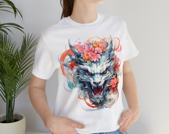 May include: White t-shirt with a graphic print of a blue and white dragon's head with pink flowers.