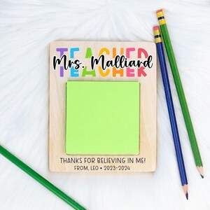 May include: A wooden teacher appreciation sign with a green sticky note, the text "Mrs. Malliard Teacher" and the message "Thanks for believing in me! From Leo - 2023-2024".