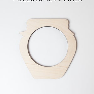 May include: A wooden jar-shaped cutout, 1/4 inch thick, made of Baltic birch plywood. The cutout is sanded and ready to paint.  It is a blank canvas for a milestone marker.
