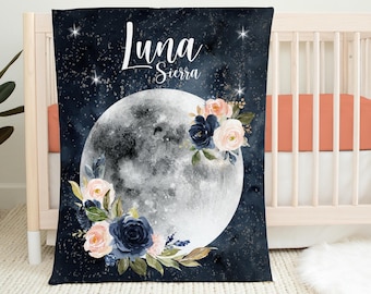 May include: A navy blue baby blanket with a large white moon and floral design. The blanket has the name "Luna Sierra" written in white cursive lettering.