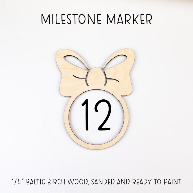 May include: Wooden milestone marker with a bow design and the number 12 in the center. The marker is made of 1/4 inch Baltic birch wood, sanded and ready to paint.