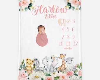 May include: A pink and white baby milestone blanket with floral accents and a jungle animal theme. The blanket features a space for a baby photo and numbers 1 through 12 to track the baby's growth. The text "Harlow Elise" is written at the top of the blanket.