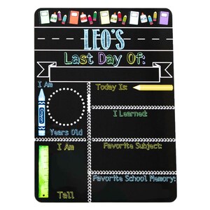 May include: Black chalkboard sign with the text "LEO'S Last Day Of:" and sections for writing about the student's age, height, favorite subject, and favorite school memory. The sign is decorated with colorful crayons, pencils, and rulers.