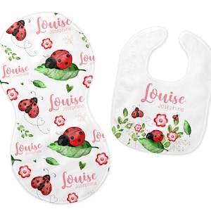 May include: A white baby burp cloth and a matching contoured changing pad cover. Both items feature a ladybug and floral design with the name "Louise Josephine" in pink script. The ladybugs are red with black spots.