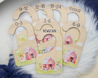 May include: Set of six wooden hangers with farm animal illustrations and size labels: Newborn, 0-3, 3-6, 6-9, 9-12, 12-18, 18-24, and Toddler.
