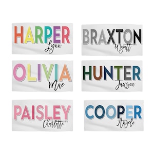 Op de afbeelding: Zes kleurrijke gepersonaliseerde strandhanddoeken met namen in een regenboog-lettertype. De namen zijn Harper, Braxton, Olivia, Hunter, Paisley en Cooper. Elke handdoek heeft een kleinere naam onder de hoofdnaam.