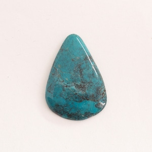 Può includere: Un cabochon di turchese a forma di lacrima con un colore blu-verde scuro e una matrice nera.