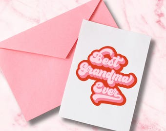 May include: A greeting card with the text "Best Grandma Ever" in a retro font, layered in shades of pink and red. The card is accompanied by a pink envelope, set against a pink marble background.