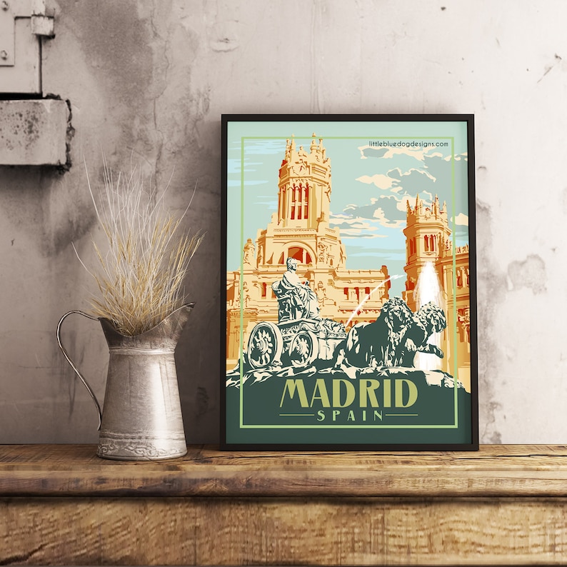 May include: A vintage travel poster design featuring a colorful illustration of a fountain with a statue of a man riding a chariot pulled by two lions in front of a building. The poster has the text "MADRID - SPAIN" at the bottom.