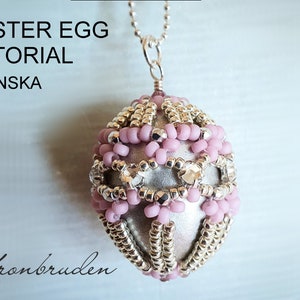 Może przedstawiać: Srebrny i różowy koralikowy wisiorek w kształcie jajka wielkanocnego z srebrnym łańcuszkiem. Jajko jest ozdobione geometrycznym wzorem z koralików i ma srebrny zamek. Tekst "EASTER EGG TUTORIAL SVENSKA" jest widoczny w górnej części obrazu.