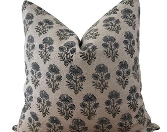 May include: A decorative throw pillow with a floral pattern. The pillow features a light beige background with a repeating pattern of blue-gray flowers. The flowers have a detailed, stylized design, adding a touch of elegance to the pillow's appearance.