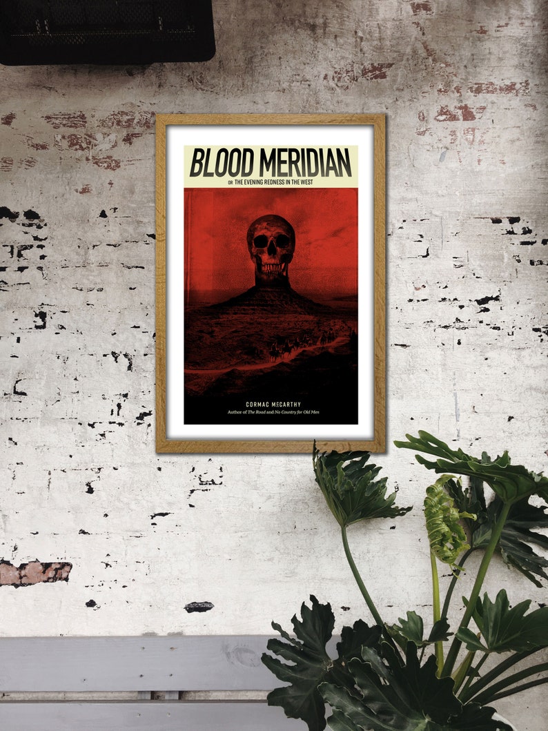 May include: A framed poster with a red background and a black skull in the center. The poster is titled "Blood Meridian" and features the text "Or The Evening Redness In The West" and "Cormac McCarthy".