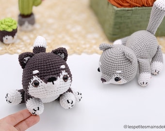 May include: Two crocheted amigurumi wolf plushies. One is gray and the other is brown and white. Both have black eyes and noses.