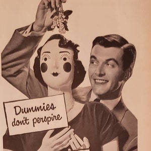 May include: A vintage advertisement for Mum deodorant, featuring a woman holding a sign that reads "Dummies don't perspire" and a man holding a sprig of berries. The ad text highlights the product's ability to kill odor bacteria and stop odor all day long. The ad also features the Mum logo and a seal from the American Institute of Laundering.