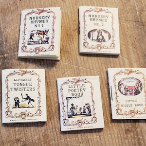 Puede incluir: Un conjunto de seis libros en miniatura con cubiertas coloridas. Los títulos incluyen "Nursery Rhymes No. 1", "Nursery Rhymes No. 2", "Alphabet Tongue Twisters", "Little Poetry Book" y "Little Riddle Book".