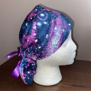 May include: Purple and blue galaxy print surgical scrub hat with a purple satin tie.
