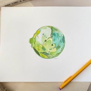 Può includere: Un dipinto ad acquerello di un globo verde e giallo con un motivo a spirale. Il globo è dipinto su uno sfondo bianco.