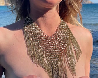 Spectacular bib necklace in mesh and gold metal fringe, it follows your movements and enhances the décolletage!