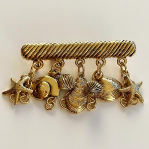 1980's- Deliciously retro this gilded brass brooch with shell charms and starfish military decoration .. pacific!