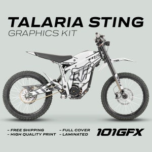 Puede incluir: Kit gráfico blanco y negro para una motocicleta eléctrica Talaria Sting. El kit incluye un logotipo de Fox Racing y el texto "Race Line Edition".