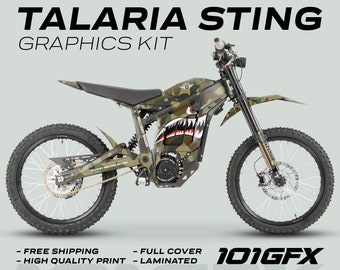 May include: A camouflage-patterned electric dirt bike with a shark graphic and the text "Military Shark" on the side. The bike has a black frame and white wheels. The text "101GFX" is visible in the lower right corner of the image.