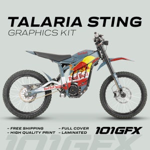 May include: A blue and red electric dirt bike with Red Bull graphics. The bike has a black seat and black handlebars. The bike is on a white background. 101GFX