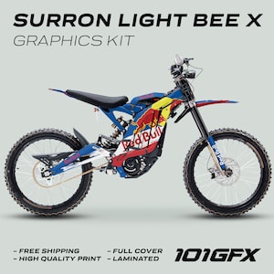 Op de afbeelding: Een aangepaste grafische set in rood, blauw en wit voor een Surron Light Bee X elektrische motorfiets. De set bevat het Red Bull logo en de tekst "101GFX".