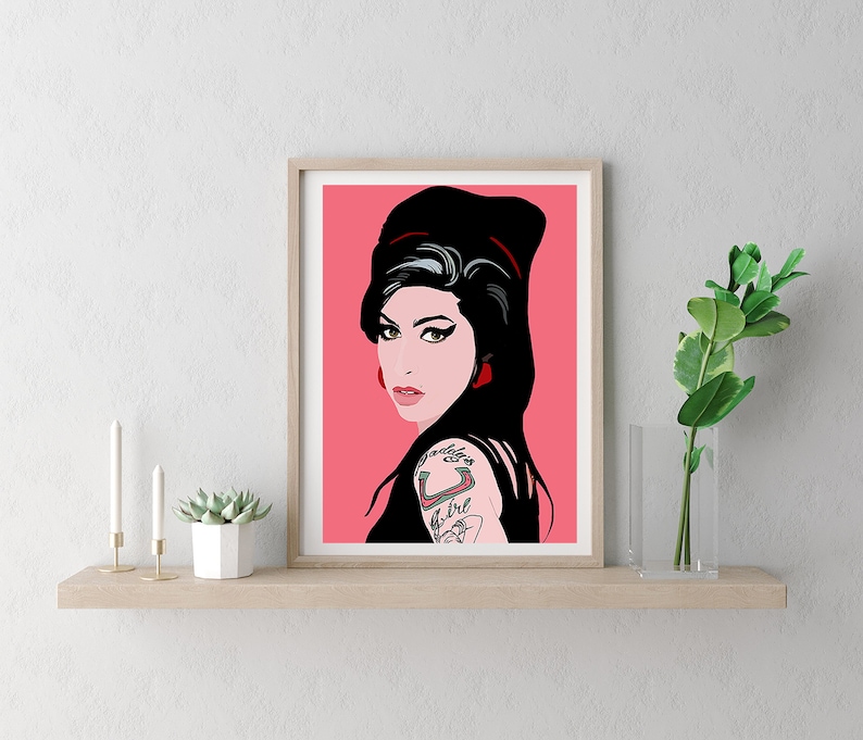 May include: A framed print of a pop art style illustration of a woman with black hair and red lipstick. The background is pink.