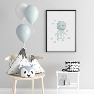 May include: A framed print of a blue jellyfish with a smiling face and small fish swimming around it. The print is hanging on a white wall with a white chair and a white side table with black and white blocks that spell "ABO" on it.