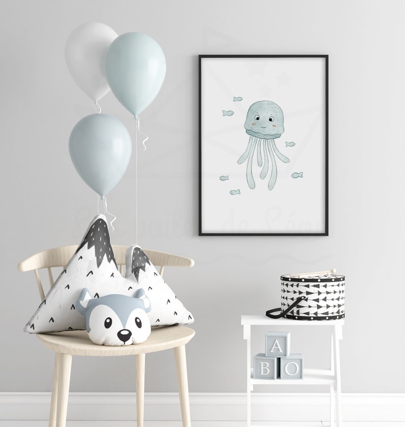 May include: A framed print of a blue jellyfish with a smiling face and small fish swimming around it. The print is hanging on a white wall with a white chair and a white side table with black and white blocks that spell "ABO" on it.