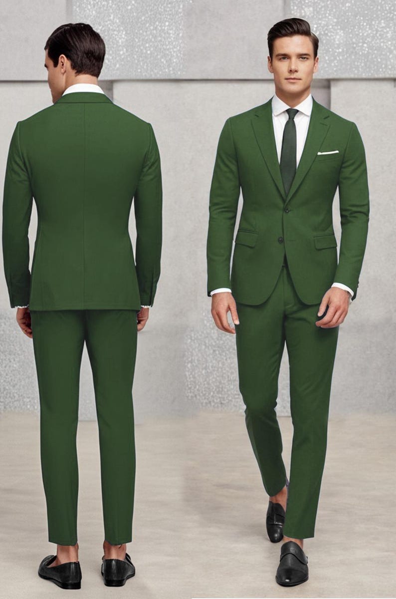 May include: A dark green suit with a single-breasted jacket and matching trousers. The jacket has a pocket on the left side and a button fastening. The suit is worn by a person with a white shirt and a dark green tie.