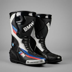 Puede incluir: Un par de botas de moto BMW Motorrad en negro, blanco y azul con el logotipo de BMW en el lateral, el texto BMW en la espinillera y el logotipo M con rayas rojas, azules y azul claro en la parte exterior del pie.
